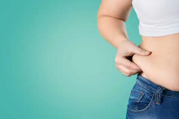 Image of woman pinching her love handles to show weight gain Chipping Norton